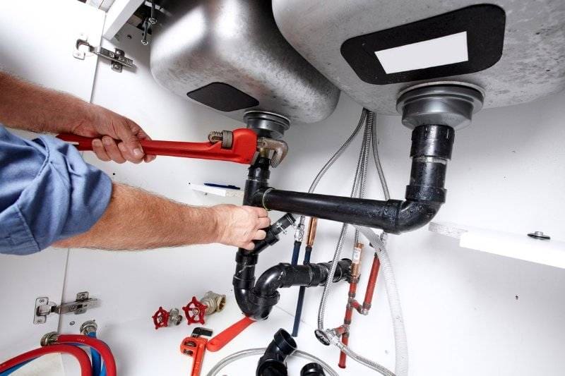 Plumberly plumber fixing sink pipes